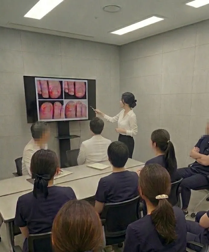 세미나실에서 강사가 발톱 증례 화면을 짚어가며 의료진 대상 교육을 진행하는 모습